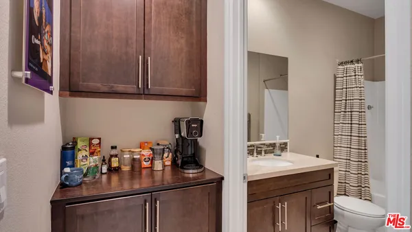 a bathroom with a granite countertop shower sink vanity mirror and toilet