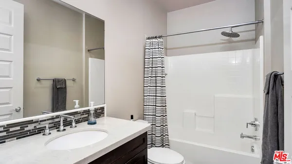 a living room with furniture a flat screen tv and a window