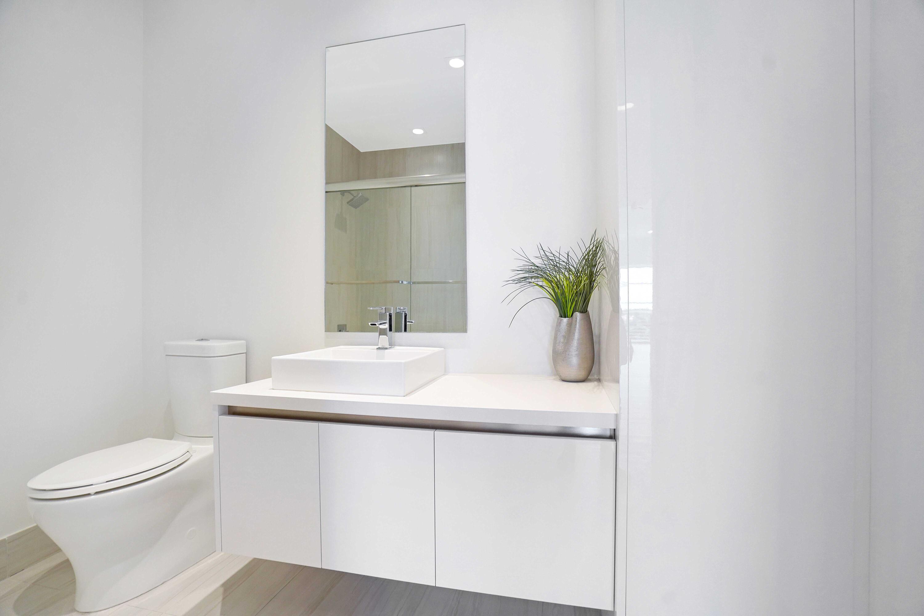 155 East Boca Raton Road, Unit 822 Boca Raton, FL 33432 - Photo 21 of 73 a bathroom with a sink a toilet and a mirror