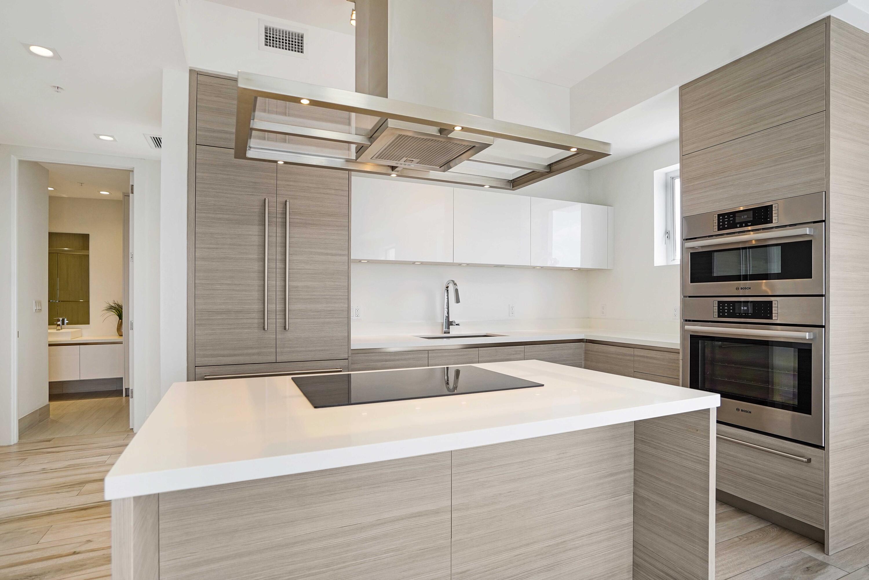 155 East Boca Raton Road, Unit 822 Boca Raton, FL 33432 - Photo 3 of 73 a kitchen with kitchen island a sink and a stove with wooden floor