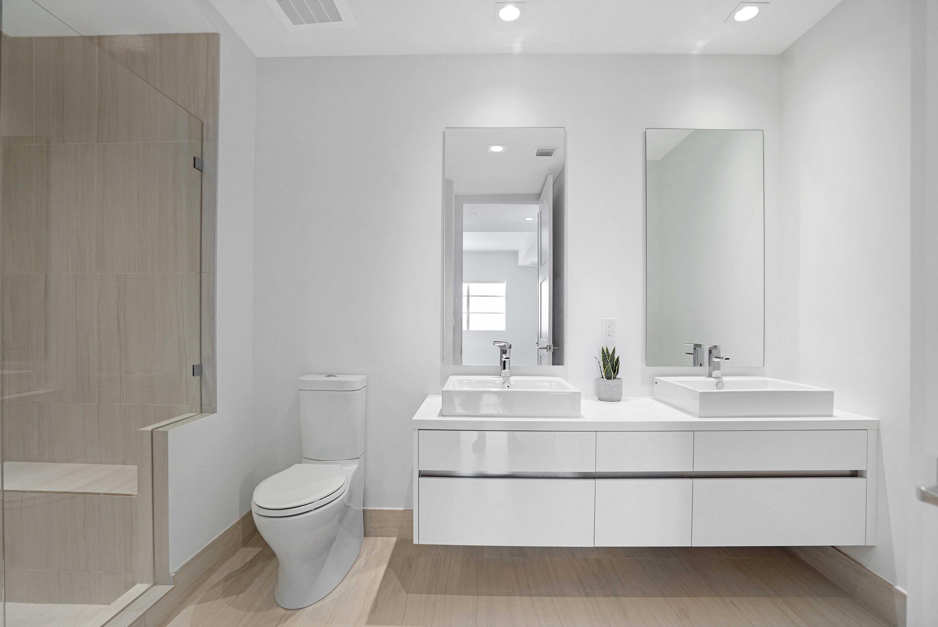 155 East Boca Raton Road, Unit 822 Boca Raton, FL 33432 - Photo 33 of 73 a bathroom with a sink mirror vanity and toilet