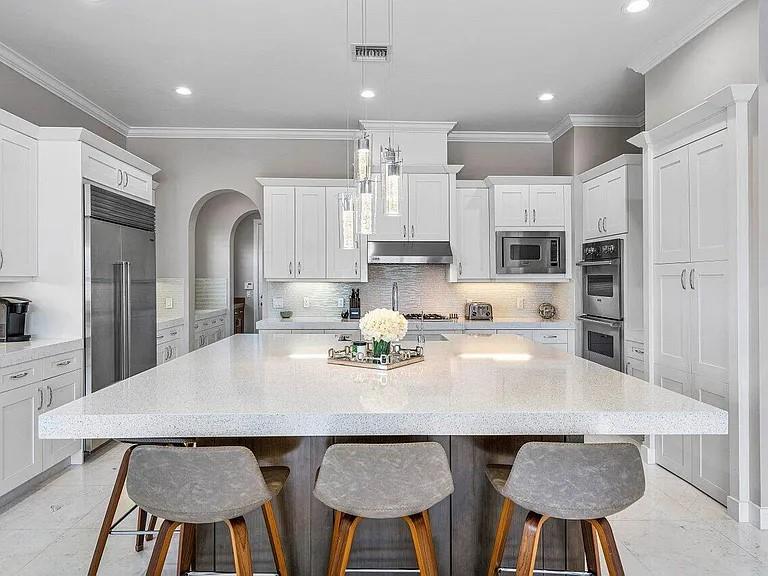 17511 Cadena Drive Boca Raton, FL 33496 - Photo 4 of 62 a kitchen with stainless steel appliances a table chairs and wooden floor