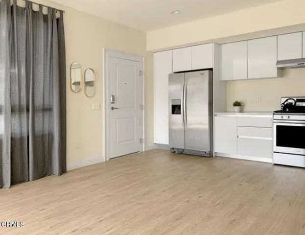 a view of a kitchen with refrigerator and cabinets