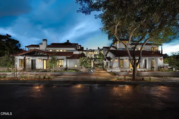 a view of a lake with house and trees in the background