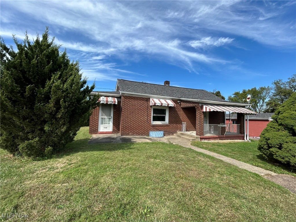164 Locust Lane Follansbee, WV 26037 - Photo 1 of 19 Bungalow featuring a front lawn, brick siding, a porch, a chimney, and a shingled roof