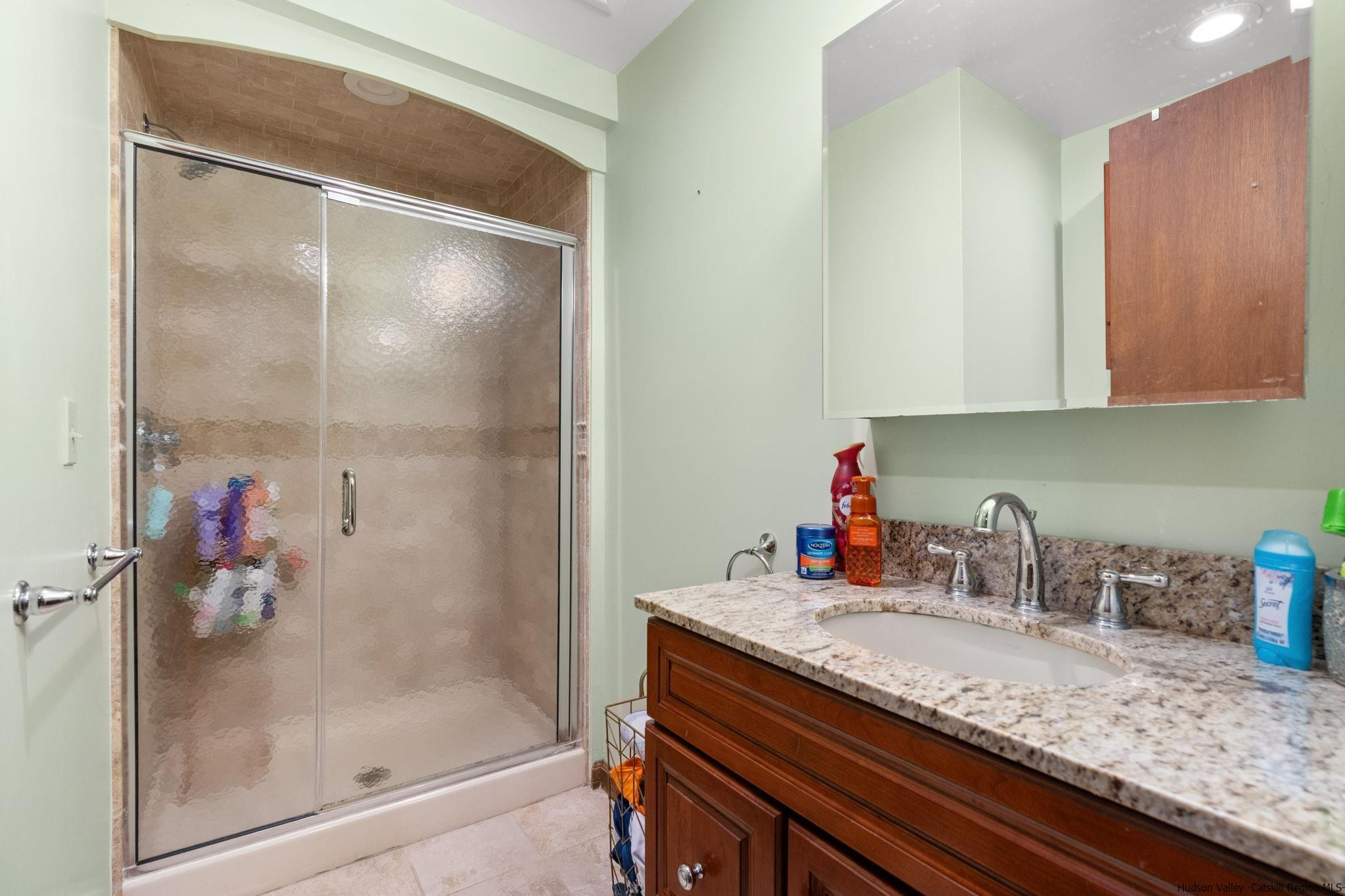 154 Mountain View Road Tillson, NY 12486 - Photo 16 of 25 a bathroom with a granite countertop sink a shower and a mirror