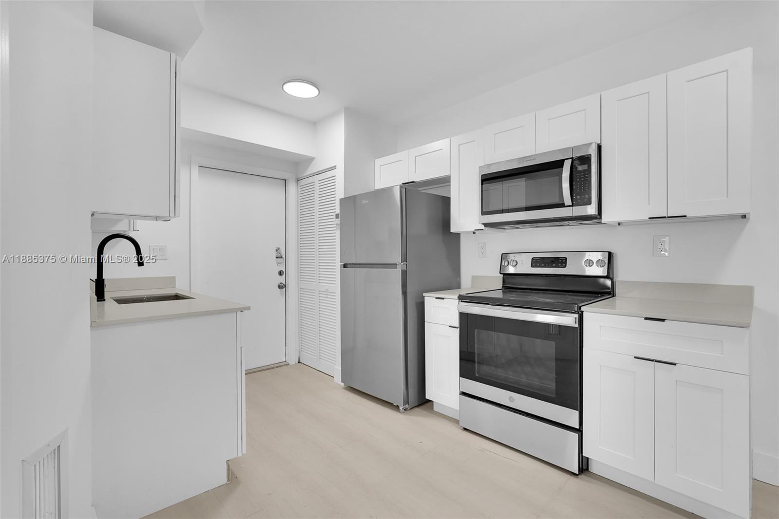 1814 Northwest 2nd Court, Unit 4 Miami, FL 33136 - Photo 1 of 13 a kitchen with stainless steel appliances white cabinets and a sink