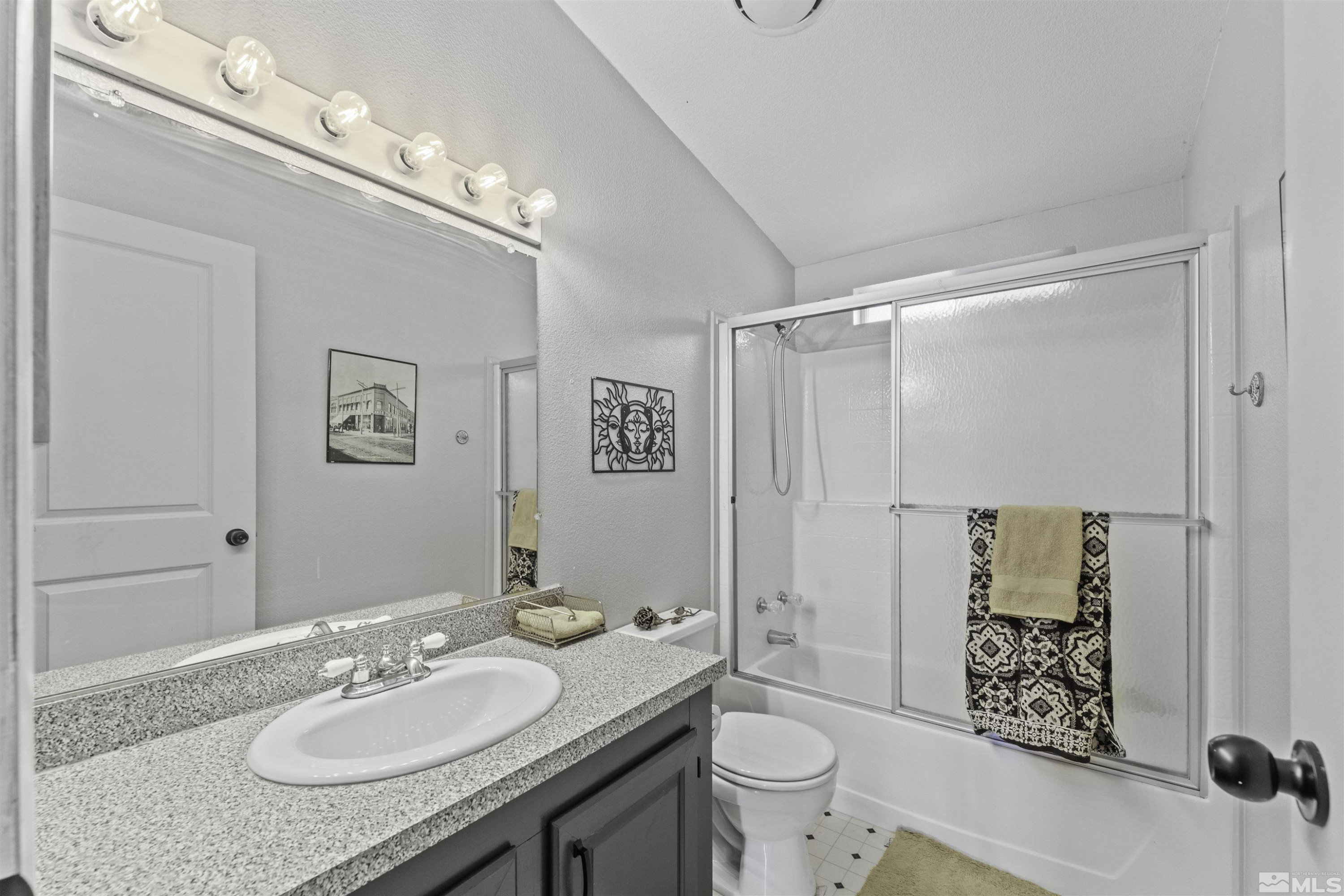 5158 Denali Way Reno, NV 89506 - Photo 13 of 24 a bathroom with a granite countertop sink a toilet a mirror and shower