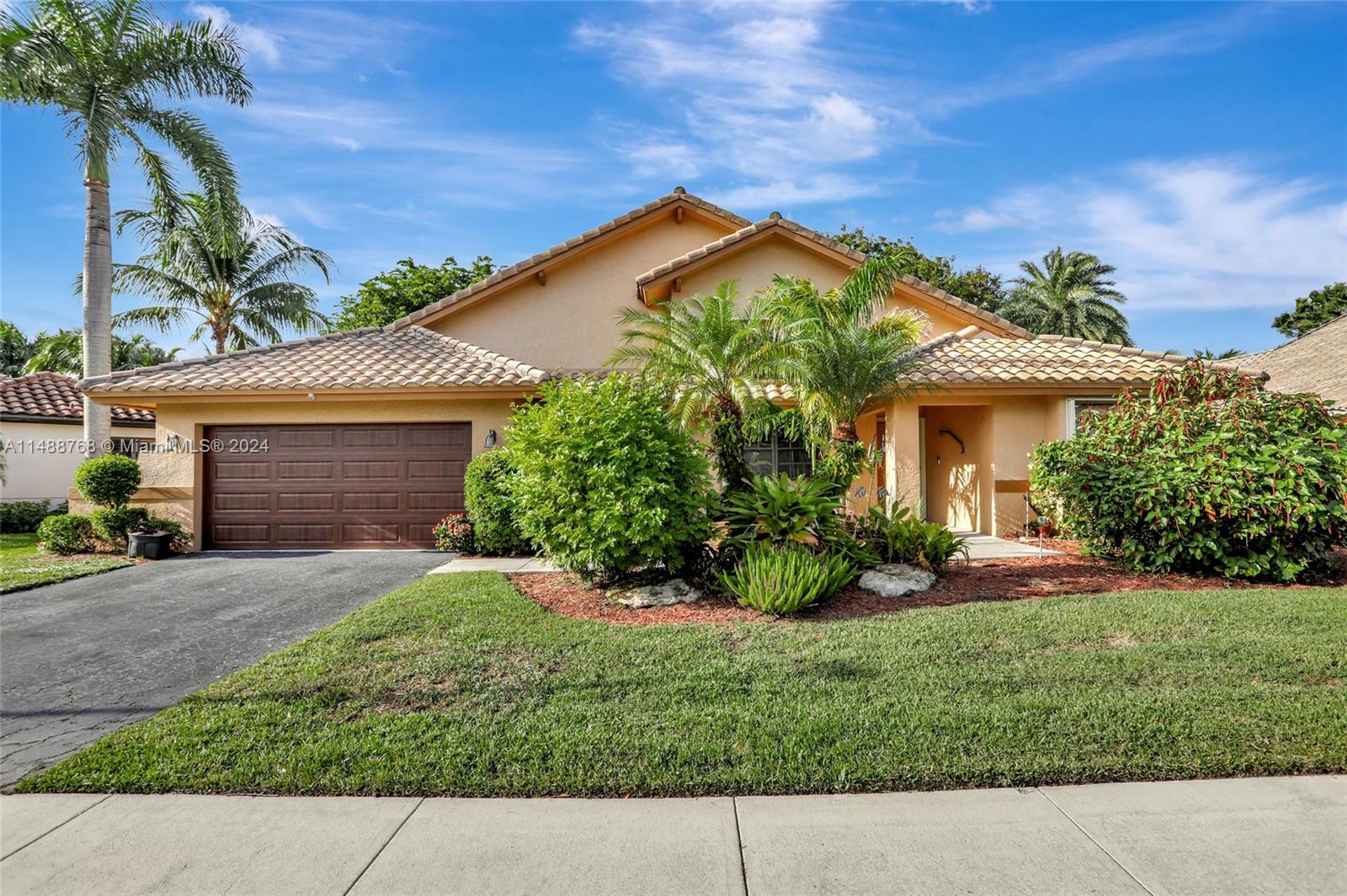 a front view of a house with a garden and plants
