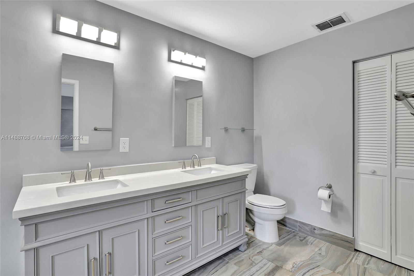9641 Ridgeside Court Davie, FL 33328 - Photo 16 of 47 a bathroom with a double vanity sink toilet and a mirror