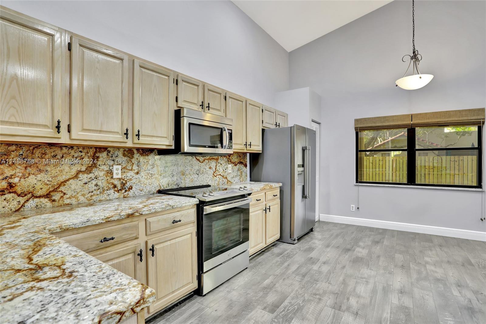 9641 Ridgeside Court Davie, FL 33328 - Photo 20 of 47 a kitchen with stainless steel appliances granite countertop a stove a sink and a refrigerator