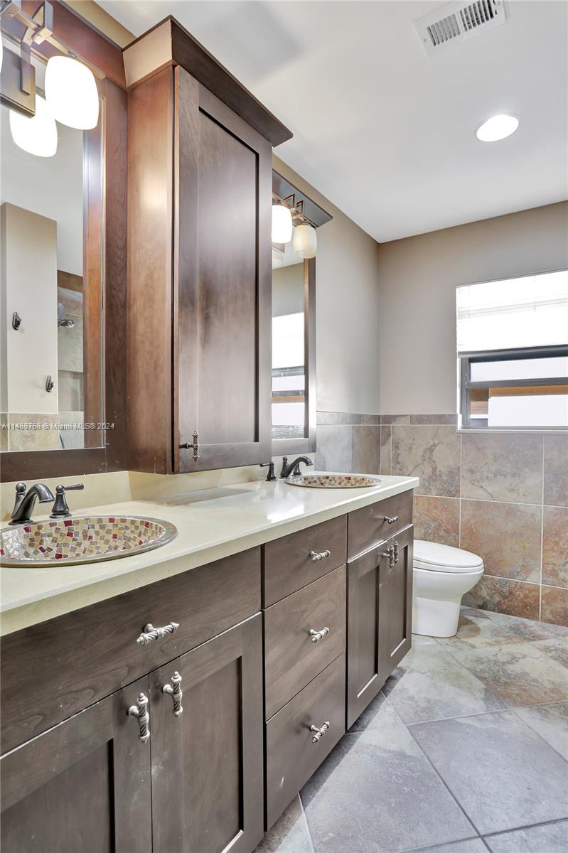 9641 Ridgeside Court Davie, FL 33328 - Photo 29 of 47 a bathroom with a granite countertop sink a toilet and a mirror