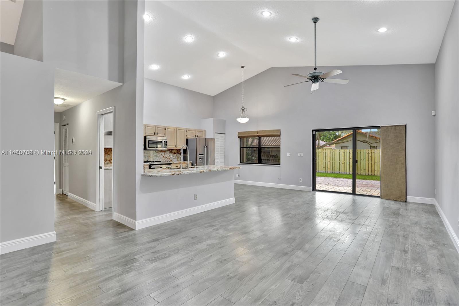 9641 Ridgeside Court Davie, FL 33328 - Photo 4 of 47 a view of an empty room and kitchen with wooden floor