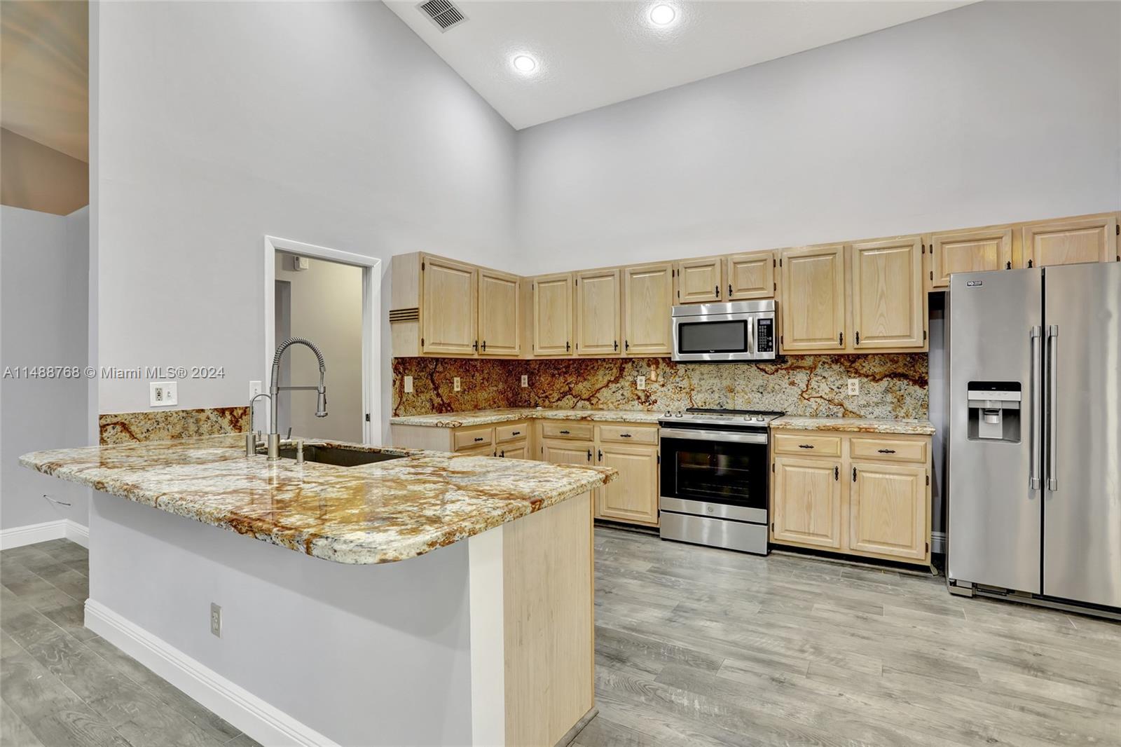 9641 Ridgeside Court Davie, FL 33328 - Photo 5 of 47 a kitchen with stainless steel appliances granite countertop a stove refrigerator and a sink