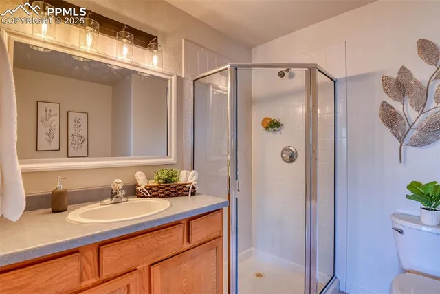 a bathroom with a granite countertop shower sink vanity and mirror