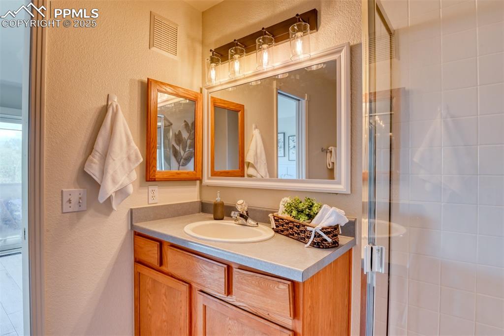 1431 Madison Ridge Heights, Unit C Colorado Springs, CO 80904 - Photo 20 of 44 a bathroom with a sink vanity and a mirror