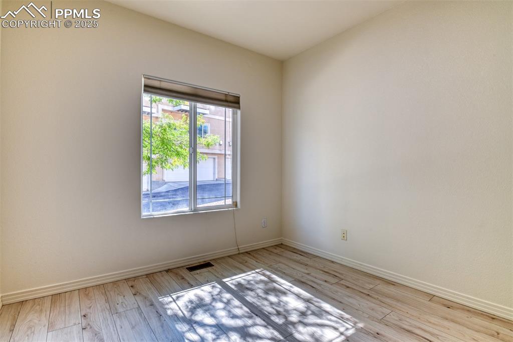 1431 Madison Ridge Heights, Unit C Colorado Springs, CO 80904 - Photo 22 of 44 an empty room with wooden floor and windows