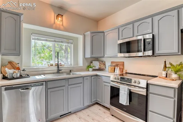 a kitchen with cabinets appliances a sink and a window