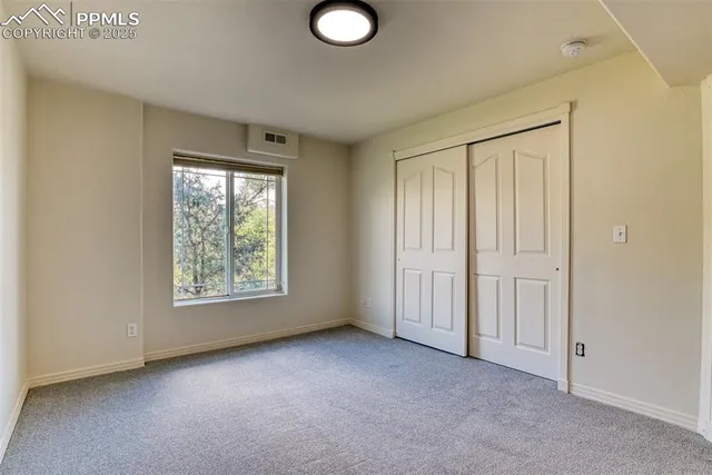 an empty room with windows and closet