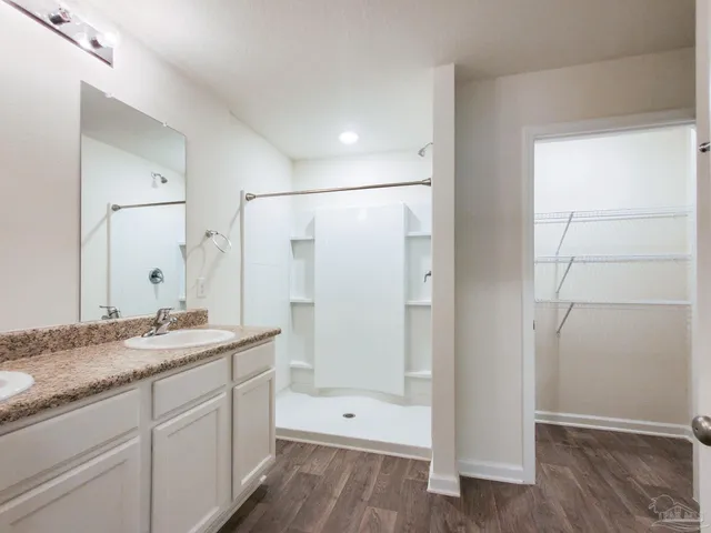 a spacious bathroom with a granite countertop sink a toilet and shower
