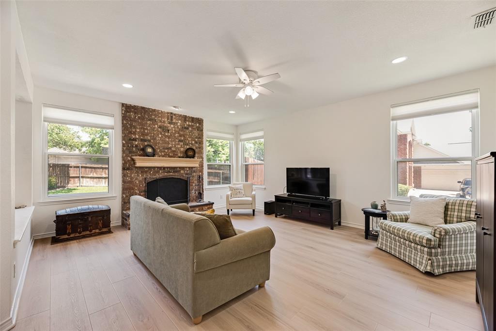 1406 West Peters Colony Road Carrollton, TX 75007 - Photo 5 of 29 a living room with furniture a flat screen tv and a fireplace