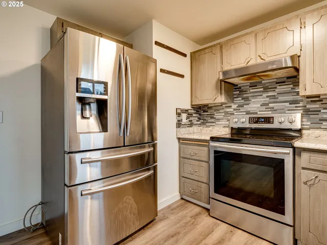 a kitchen with stainless steel appliances granite countertop a stove a sink and a microwave
