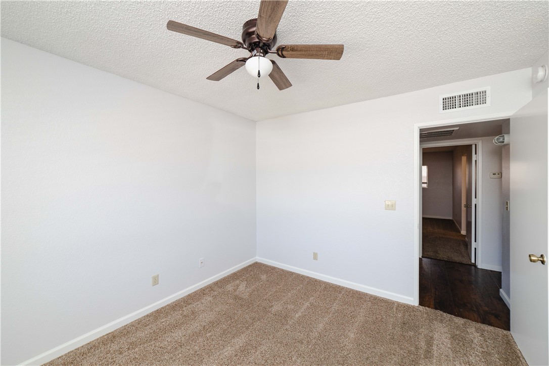 980 Canyon Hills Road Kingman, AZ 86409 - Photo 27 of 42 an empty room with a ceiling fan and carpet