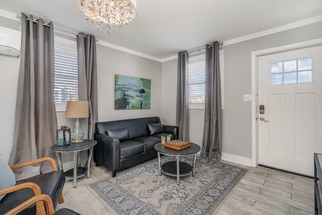 a living room with furniture a window and a chandelier