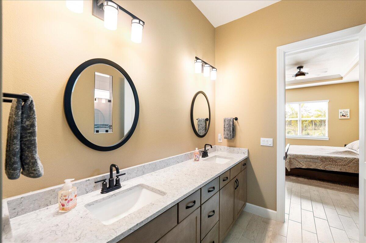 9941 Southwest Legacy Drive Stuart, FL 34997 - Photo 13 of 33 a bathroom with a double vanity sink and a mirror