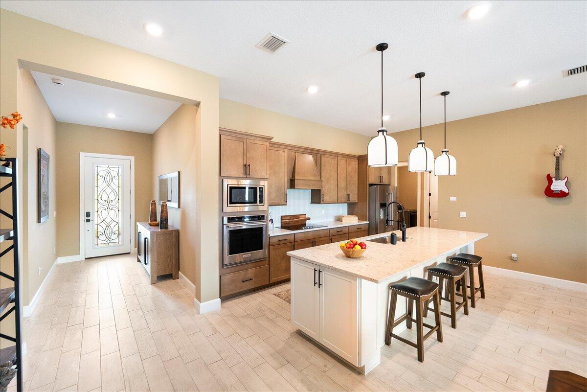 9941 Southwest Legacy Drive Stuart, FL 34997 - Photo 2 of 33 a large kitchen with a table and chairs