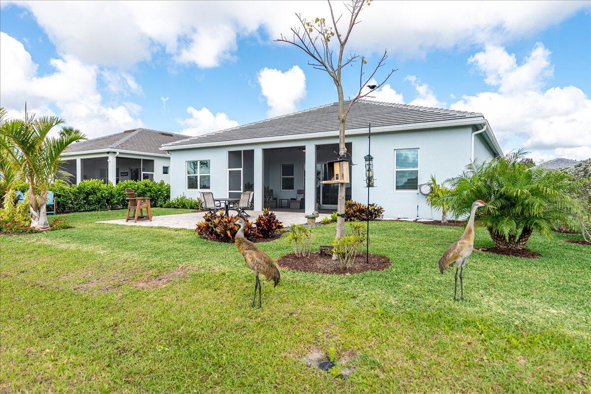 9941 Southwest Legacy Drive Stuart, FL 34997 - Photo 27 of 33 a view of a house with a backyard and a patio