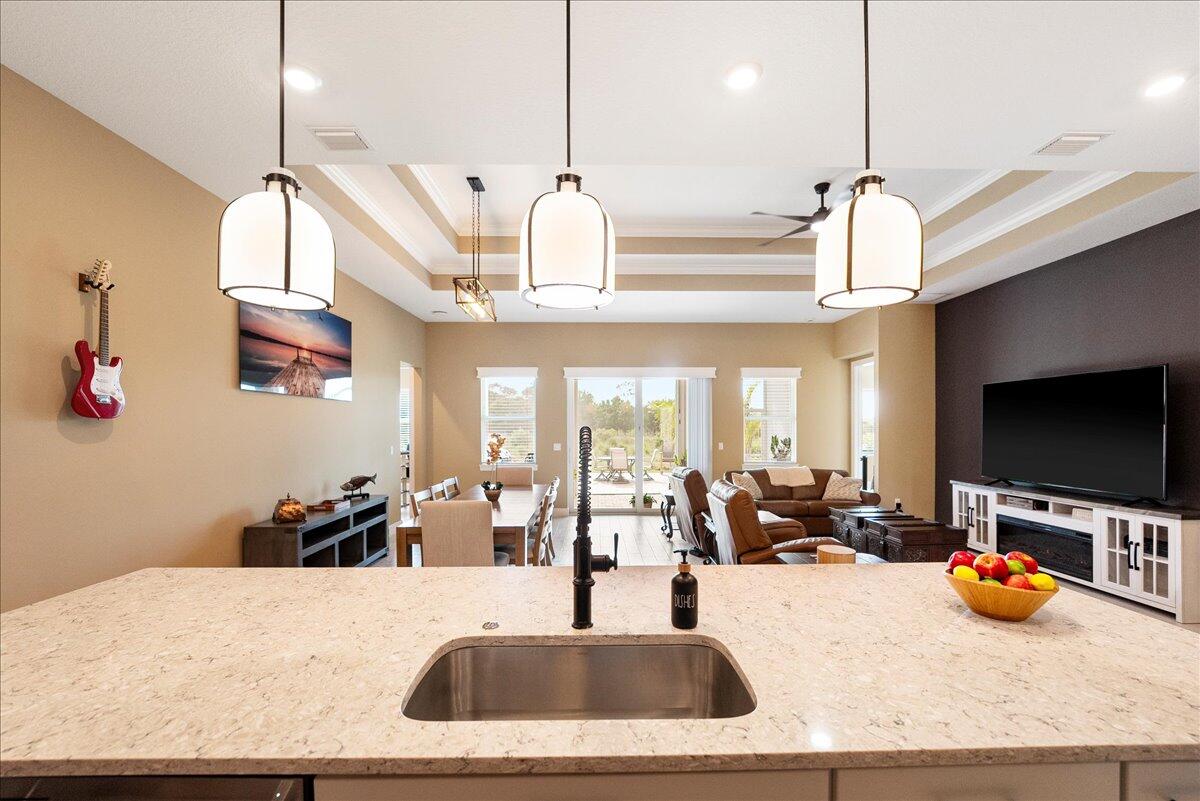 9941 Southwest Legacy Drive Stuart, FL 34997 - Photo 6 of 33 a kitchen with stainless steel appliances kitchen island granite countertop a sink and a flat screen tv