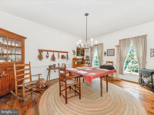 a dining room with furniture a chandelier and wooden floor