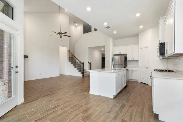 a kitchen with white cabinets and stainless steel appliances