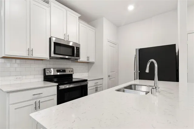 a kitchen with stainless steel appliances a stove sink microwave and cabinets