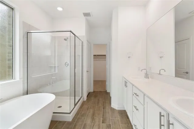 a spacious bathroom with a double vanity sink and a mirror