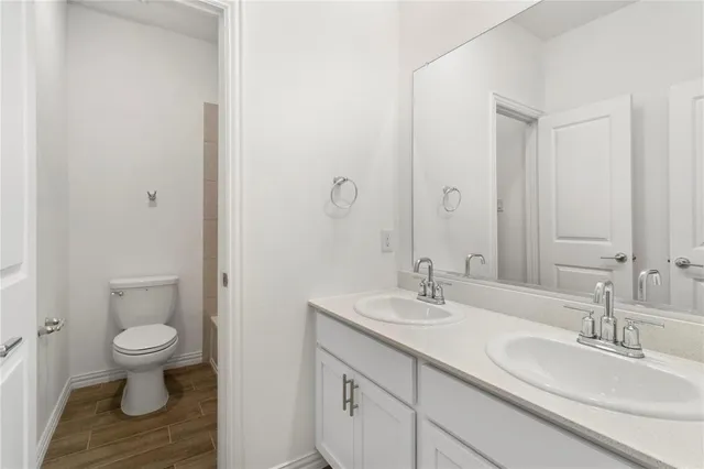 a bathroom with a granite countertop sink toilet and a mirror
