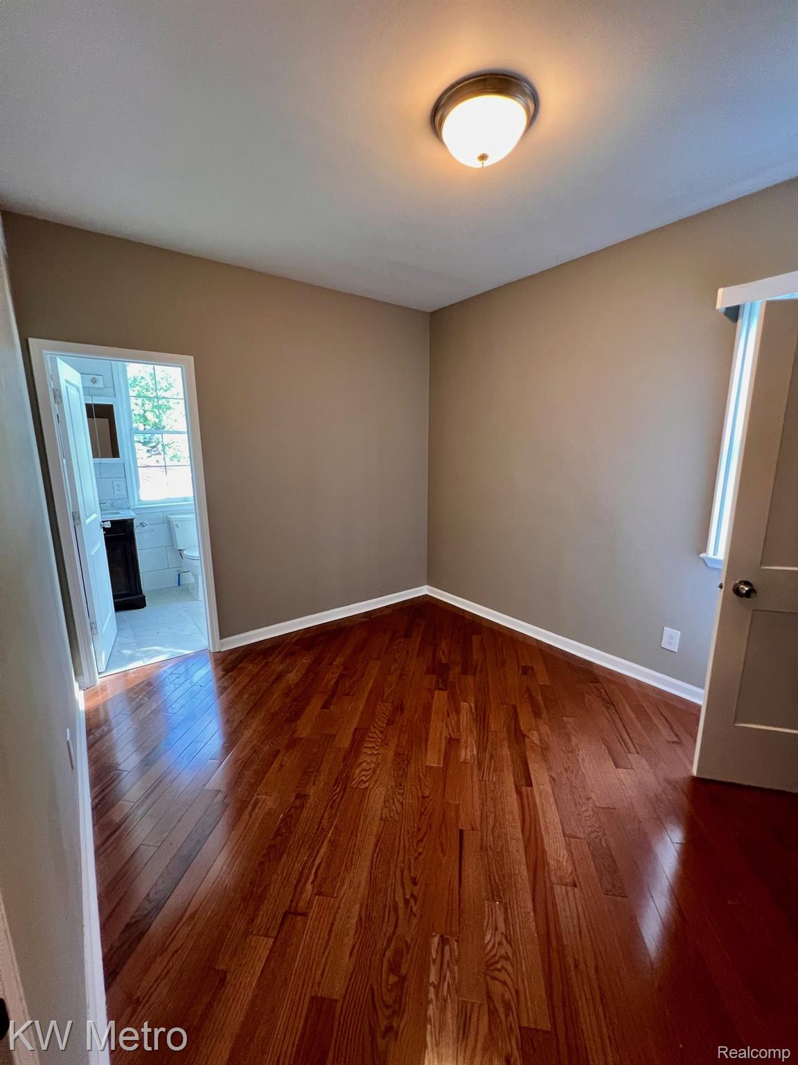 939 Webb Street Detroit, MI 48202 - Photo 10 of 19 Room featuring wood-finish flooring, neutral wall tones, white baseboards, and a semi-flush mount ceiling light