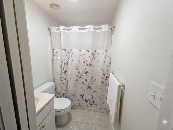 a bathroom with a toilet and a shower curtain