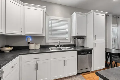 a kitchen with granite countertop white cabinets and white appliances