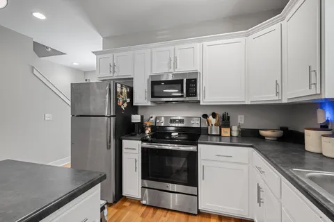 a kitchen with stainless steel appliances granite countertop a refrigerator stove a sink and a microwave