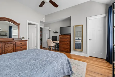 a bedroom with a bed dresser and a flat tv screen