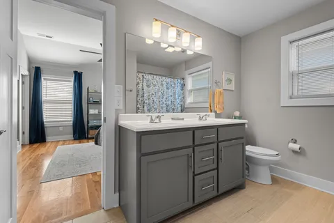 a bathroom with a double vanity sink a toilet and a mirror