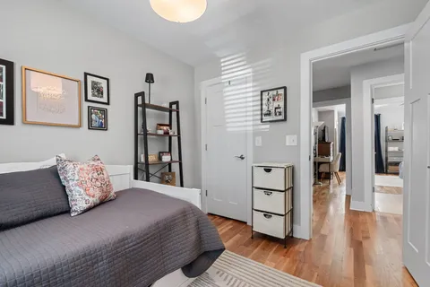 a spacious bedroom with a bed and a wooden floor