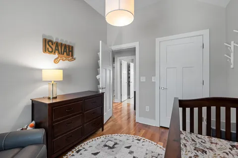 a bedroom with a bed and wooden floor