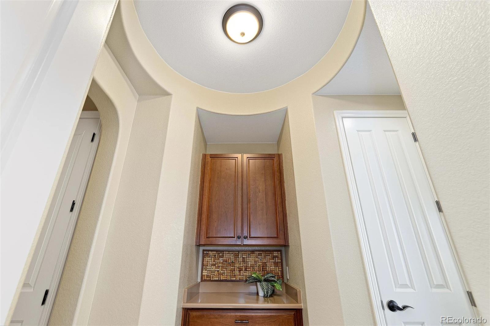 9581 Firenze Way Highlands Ranch, CO 80126 - Photo 16 of 48 a view of a hallway with wooden floor and a cabinet