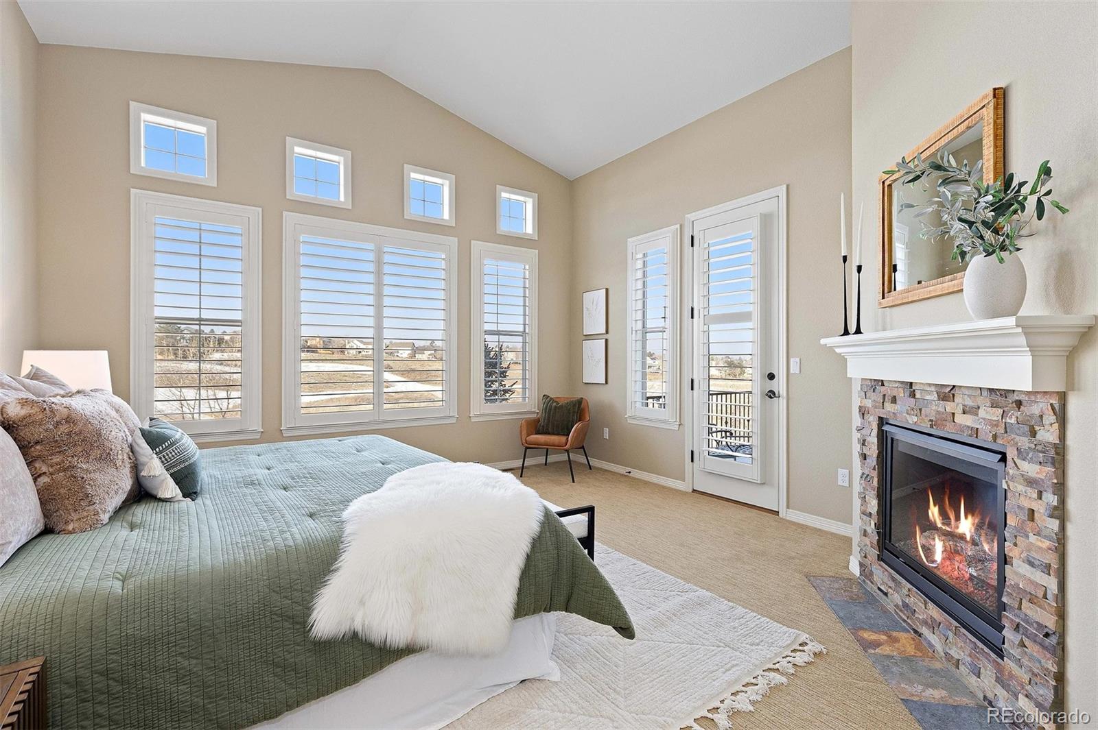 9581 Firenze Way Highlands Ranch, CO 80126 - Photo 2 of 48 a spacious bedroom with a large bed and a fireplace