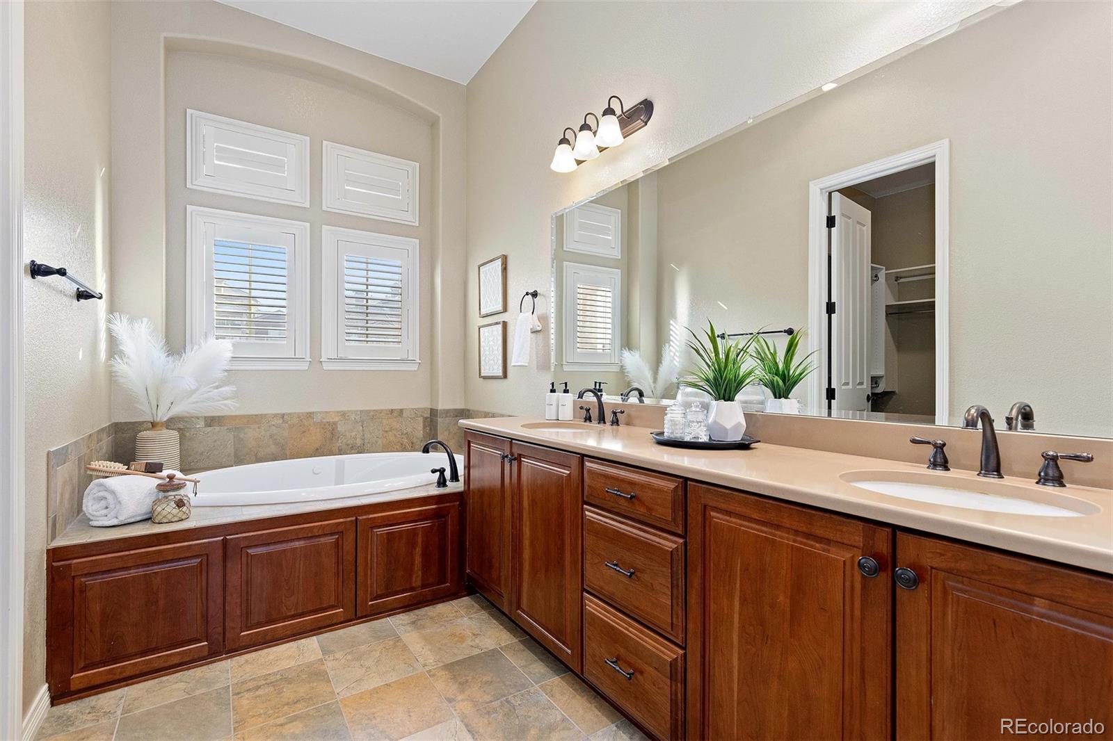 9581 Firenze Way Highlands Ranch, CO 80126 - Photo 21 of 48 a bathroom with a tub double sink window and mirror