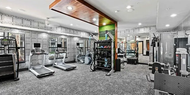 a living room with furniture a large window and stainless steel appliances