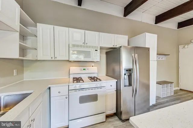 a kitchen with a refrigerator sink stove and cabinets